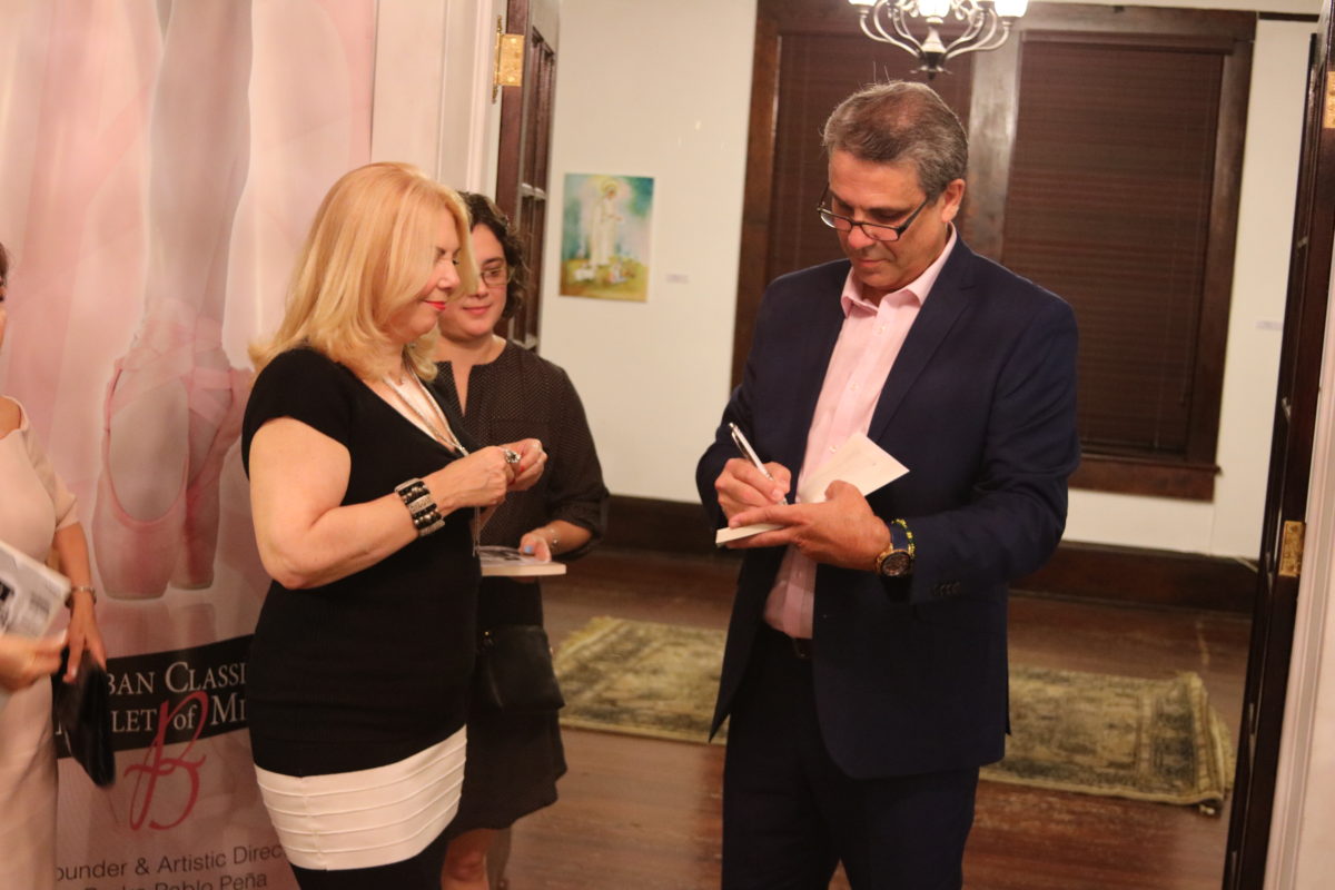 El escritor Denis Fortún firma un ejemplar durante la presentación de su nueva novela.